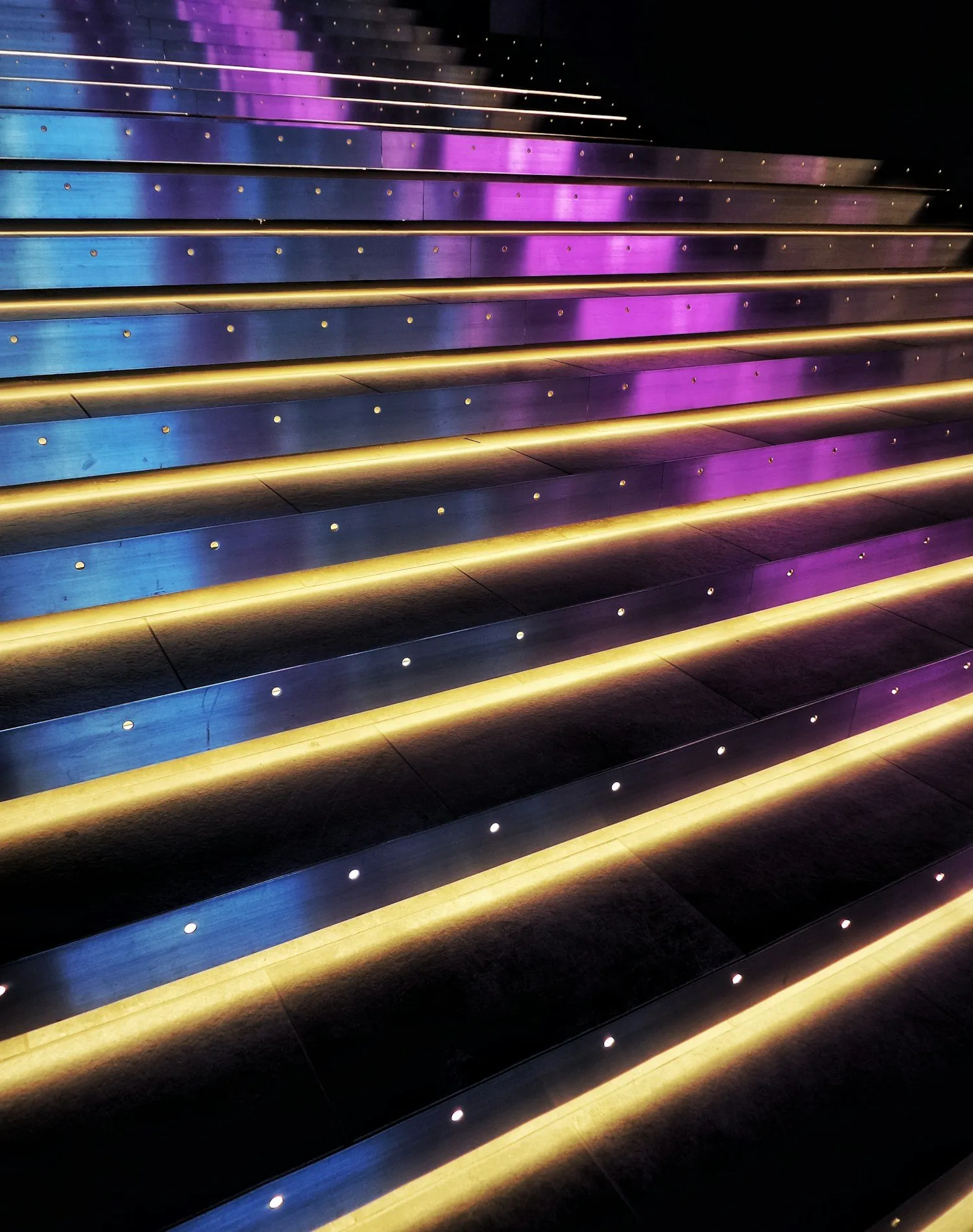 Un escalier dont chaque marche est soulignée d’une bande lumineuse, les étapes à franchir